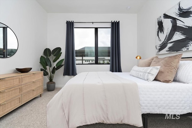 bedroom with light colored carpet and baseboards