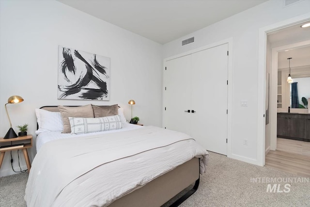 bedroom featuring baseboards, carpet, a closet, and visible vents