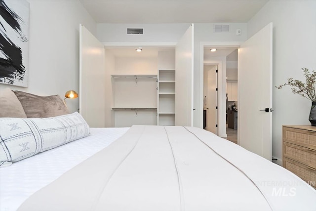 bedroom featuring visible vents, a walk in closet, and a closet