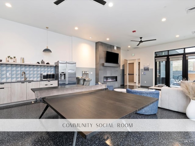 living area with a ceiling fan, recessed lighting, a tile fireplace, and visible vents