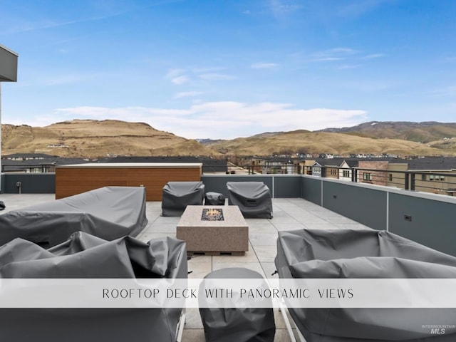 view of patio / terrace featuring a mountain view and an outdoor living space with a fire pit