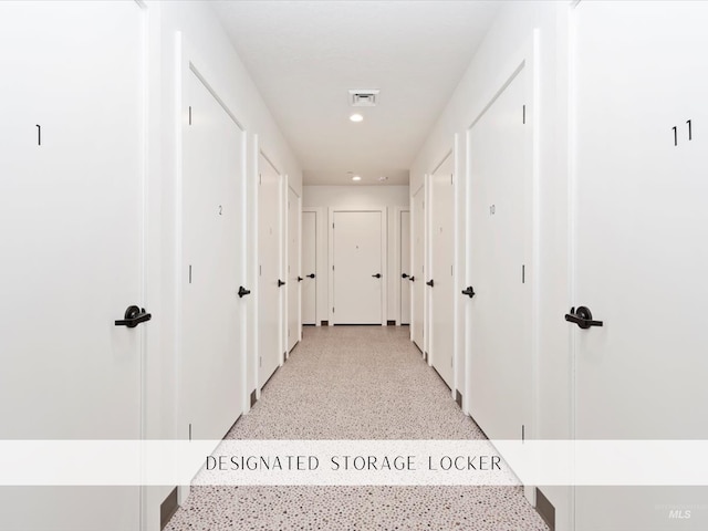 hall featuring recessed lighting, visible vents, and light speckled floor