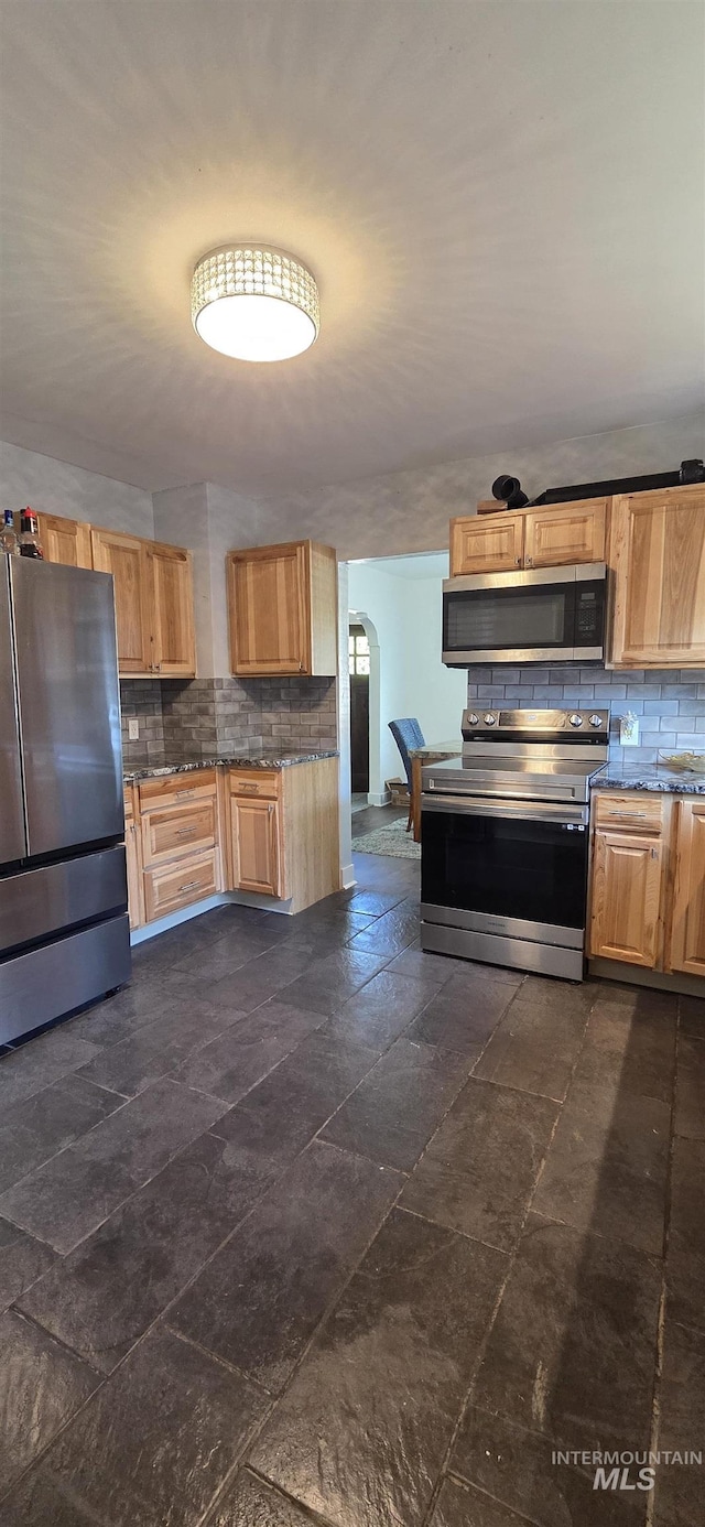1118 10th St, Lewiston, ID 83501 - kitchen featuring stainless steel appliances, decorative backsplash, arched walkways, and light brown cabinetry