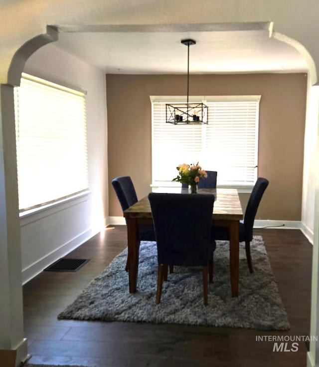 1118 10th St, Lewiston, ID 83501 - dining area with a chandelier, healthy amount of natural light, dark wood-style flooring, and arched walkways