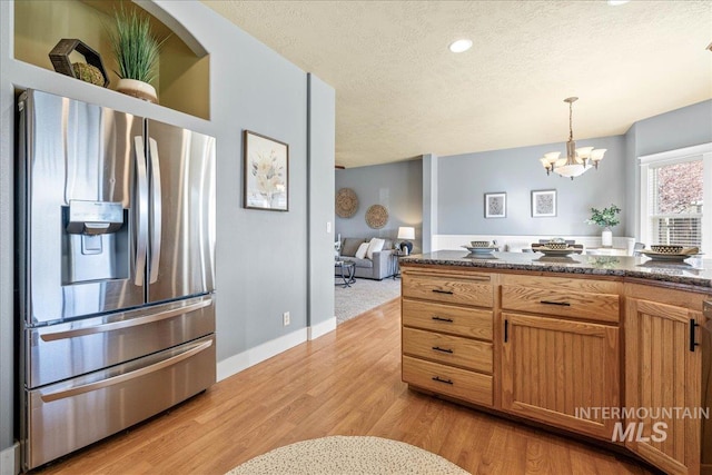 568 S Wooddale Pl, Eagle, ID 83616 - kitchen featuring dark stone countertops, a textured ceiling, stainless steel fridge with ice dispenser, light wood finished floors, and decorative light fixtures