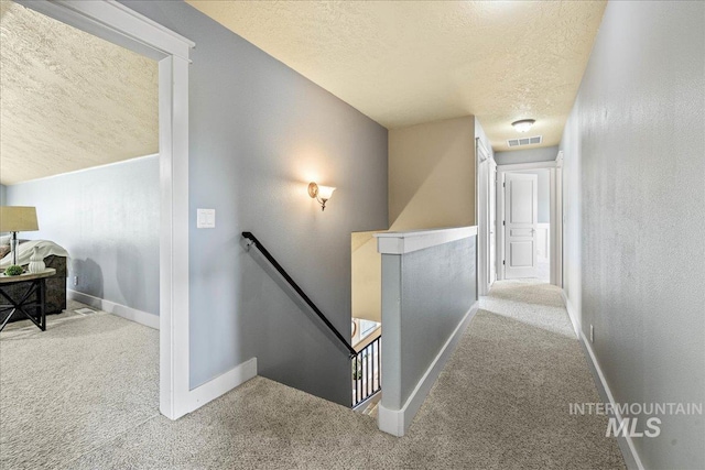 568 S Wooddale Pl, Eagle, ID 83616 - corridor featuring an upstairs landing, a textured ceiling, carpet, baseboards, and visible vents