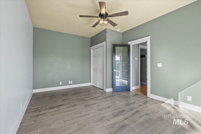 568 S Wooddale Pl, Eagle, ID 83616 - unfurnished bedroom with wood finished floors, a closet, a ceiling fan, and baseboards
