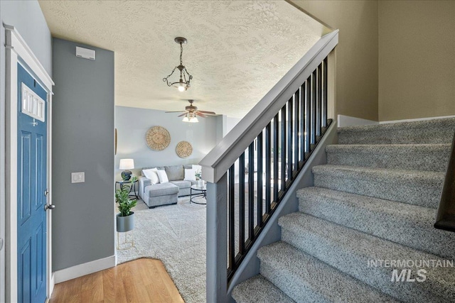 568 S Wooddale Pl, Eagle, ID 83616 - stairs with wood finished floors, a textured ceiling, a ceiling fan, and baseboards