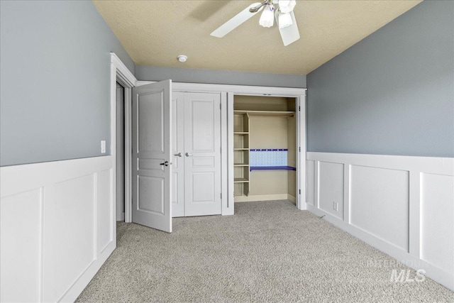 568 S Wooddale Pl, Eagle, ID 83616 - unfurnished bedroom featuring a wainscoted wall, carpet, a closet, and ceiling fan