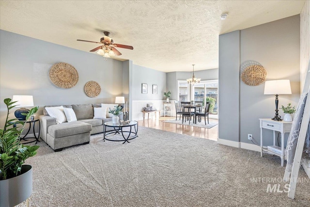568 S Wooddale Pl, Eagle, ID 83616 - carpeted living room featuring a textured ceiling, baseboards, and ceiling fan with notable chandelier