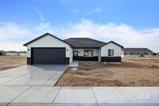 modern farmhouse with a garage, board and batten siding, and driveway