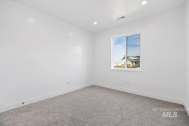 carpeted empty room featuring recessed lighting, visible vents, and baseboards