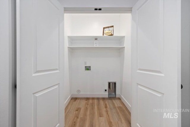 clothes washing area with baseboards, hookup for an electric dryer, laundry area, light wood-style flooring, and washer hookup