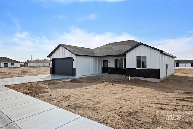 modern farmhouse style home featuring board and batten siding, concrete driveway, an attached garage, and a shingled roof