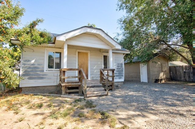 view of front facade featuring an outbuilding and fence