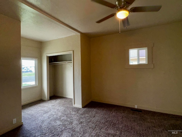 unfurnished bedroom with carpet flooring, baseboards, a closet, and ceiling fan