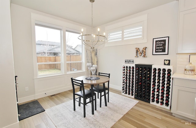 520 S Prospector Ln, Eagle, ID 83616 - dining space featuring a chandelier, plenty of natural light, light wood-style flooring, and baseboards