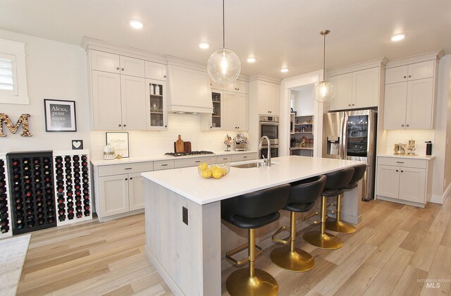 520 S Prospector Ln, Eagle, ID 83616 - kitchen with a sink, light wood-type flooring, a breakfast bar, appliances with stainless steel finishes, and recessed lighting