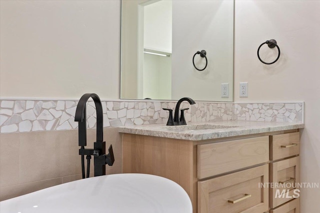 bathroom with vanity and tile walls