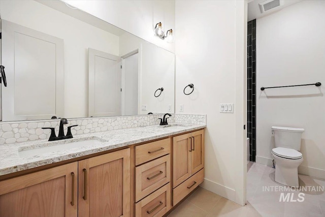 bathroom featuring toilet, tile patterned flooring, tasteful backsplash, and vanity