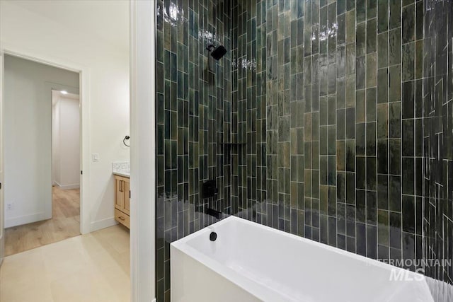 bathroom with vanity and tiled shower / bath