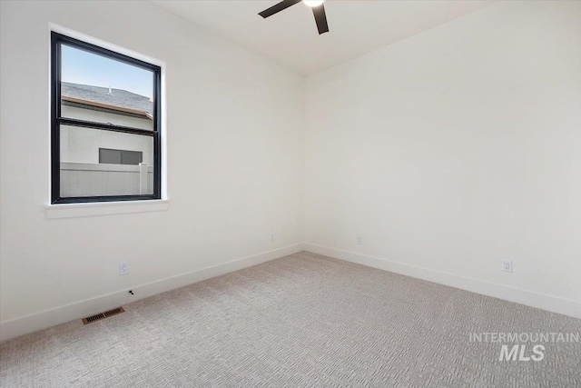 carpeted spare room with ceiling fan