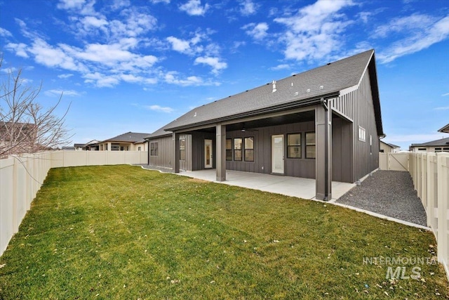 back of house with a lawn and a patio