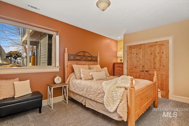 carpeted bedroom with a closet and a textured ceiling