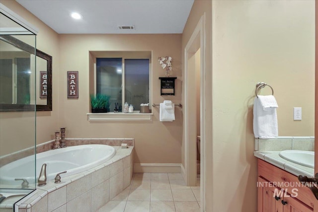 bathroom featuring vanity, tiled bath, and tile patterned flooring