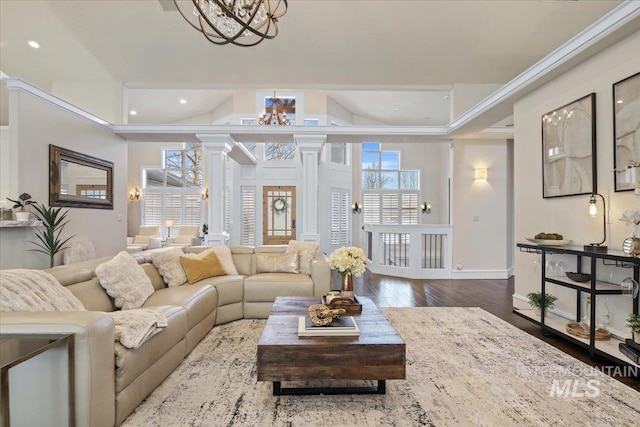 living room featuring an inviting chandelier, hardwood / wood-style floors, and ornate columns