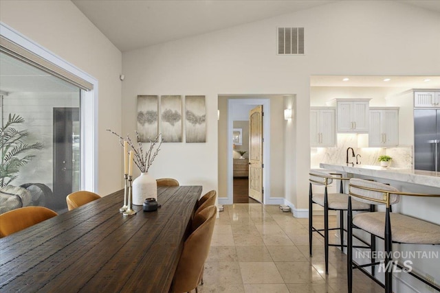 dining area with sink and vaulted ceiling