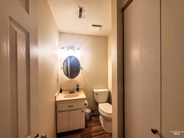 2315 NW 14th St, Meridian, ID 83646 - half bathroom featuring wood finished floors, toilet, vanity, a textured ceiling, and a textured wall