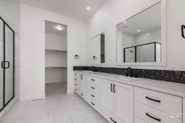 bathroom with vanity and a shower with door