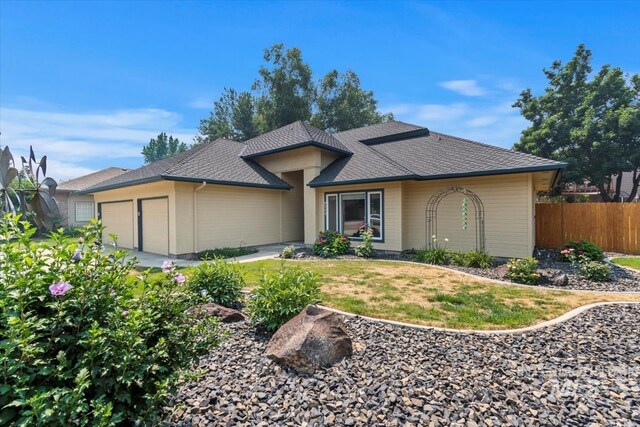 single story home featuring a garage and a front lawn