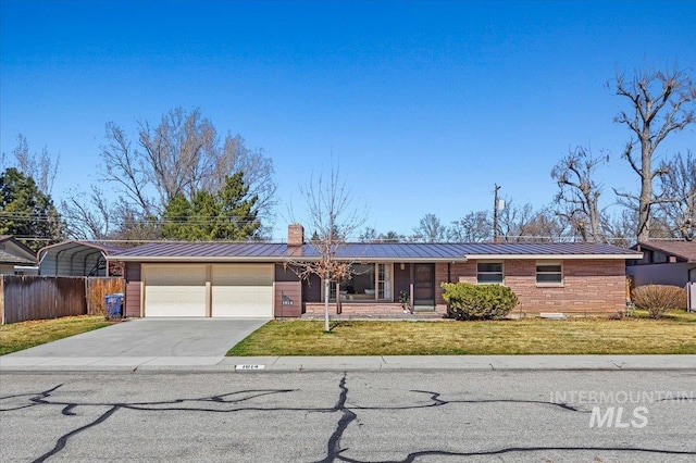 ranch-style home with a standing seam roof, fence, concrete driveway, a front yard, and metal roof