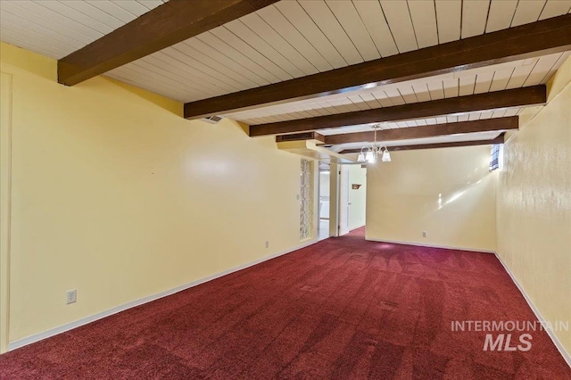 carpeted spare room featuring an inviting chandelier, beam ceiling, wood ceiling, and baseboards