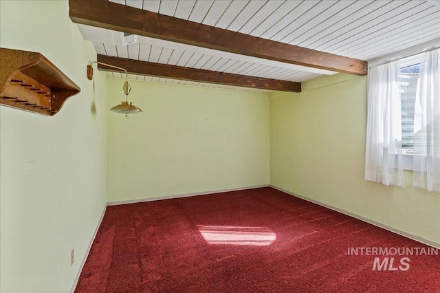 carpeted spare room featuring baseboards, beam ceiling, and wood ceiling