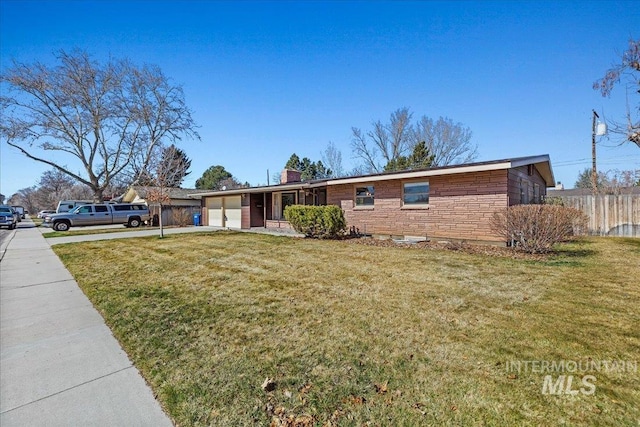 ranch-style house featuring stone siding, a garage, concrete driveway, and a front lawn