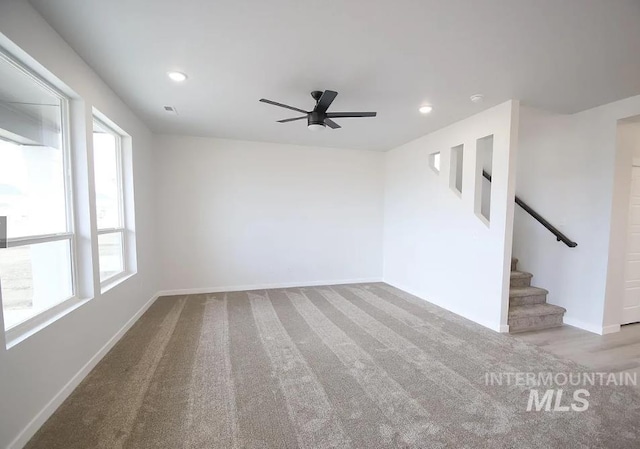 unfurnished living room with baseboards, a ceiling fan, carpet floors, recessed lighting, and stairway