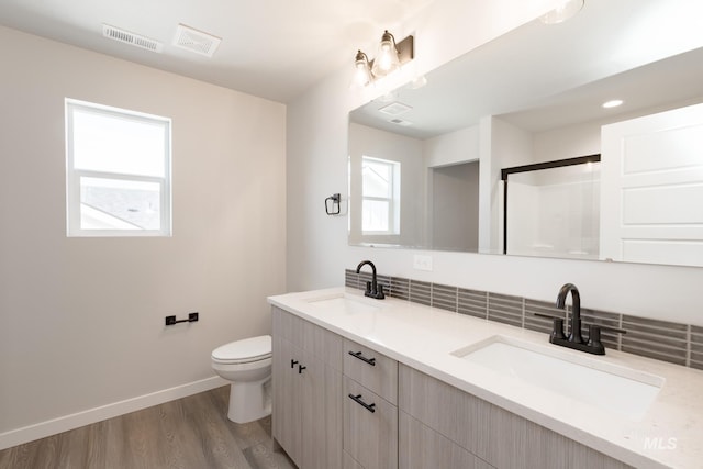 bathroom featuring a wealth of natural light, a sink, and baseboards