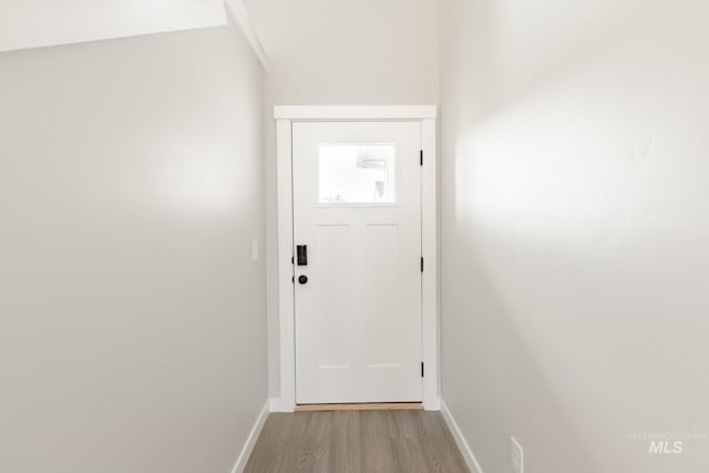 doorway with baseboards and light wood-style floors