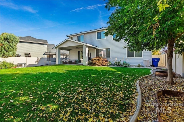 rear view of house featuring a yard