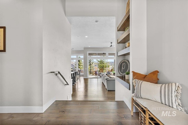 entryway with recessed lighting, a textured ceiling, baseboards, and wood finished floors