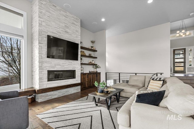 living area featuring recessed lighting, a chandelier, wood finished floors, and a fireplace