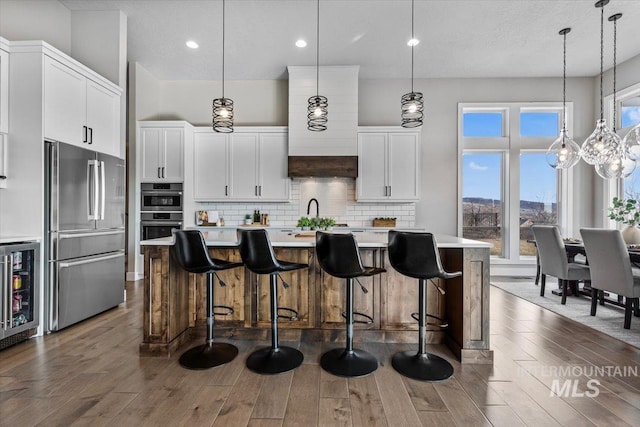 kitchen featuring light countertops, wine cooler, backsplash, and stainless steel appliances