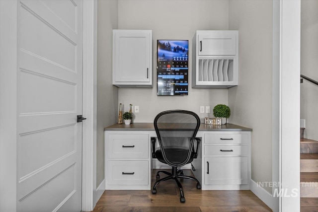 office area with dark wood-type flooring, baseboards, and built in study area