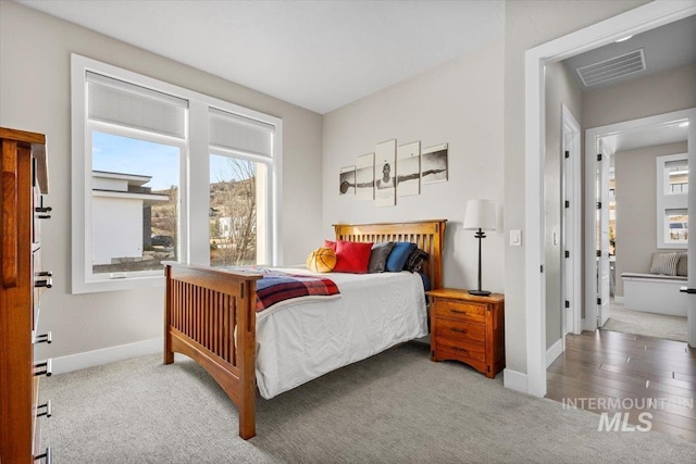 carpeted bedroom with baseboards and visible vents