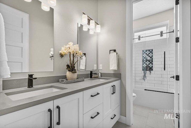 bathroom with a sink, toilet,  shower combination, and double vanity