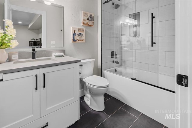 full bath featuring tile patterned flooring, toilet, vanity, and shower / bath combination with glass door