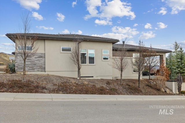 view of home's exterior with stucco siding and stone siding